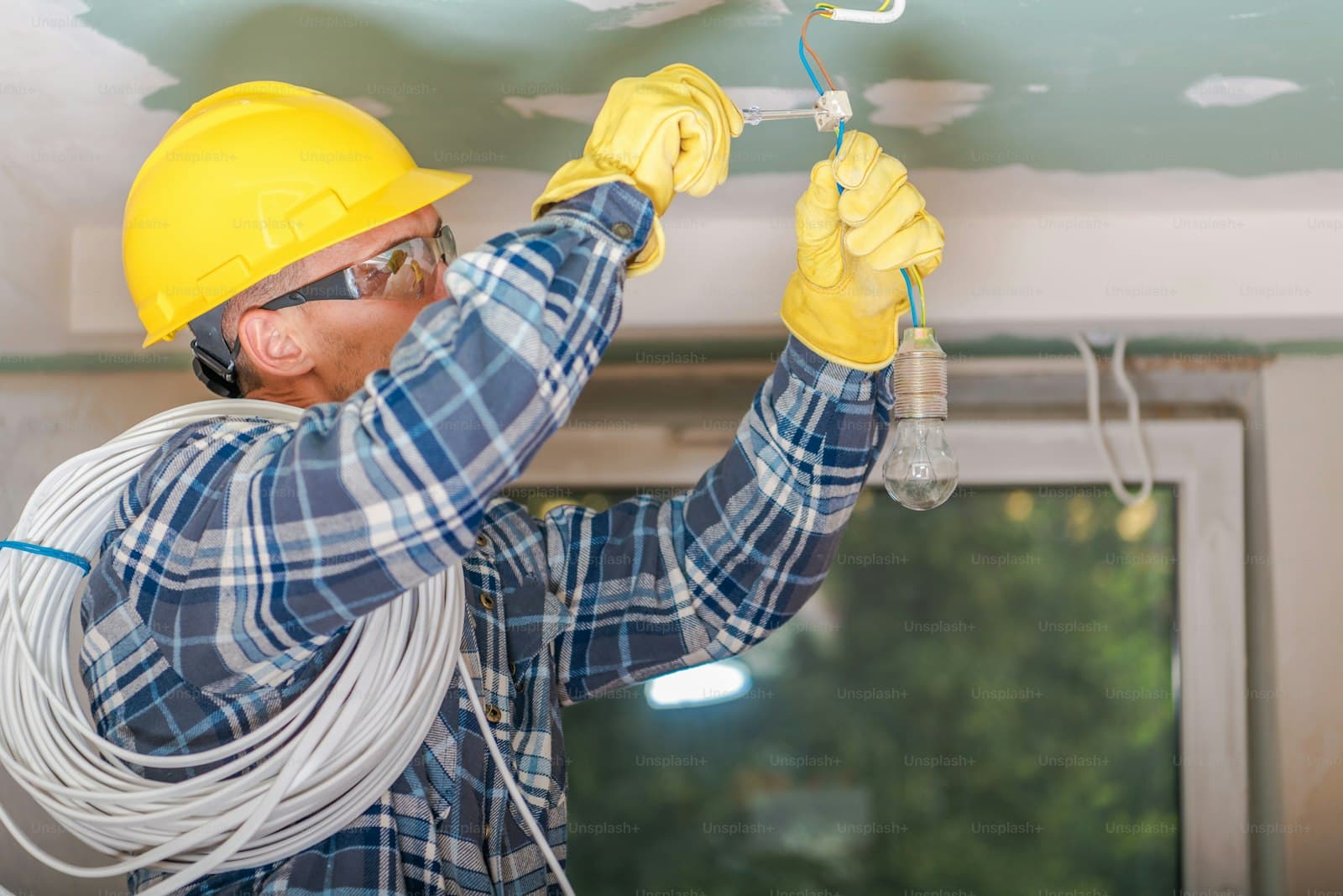Électricien intervenant sur une installation basse tension avec EPI